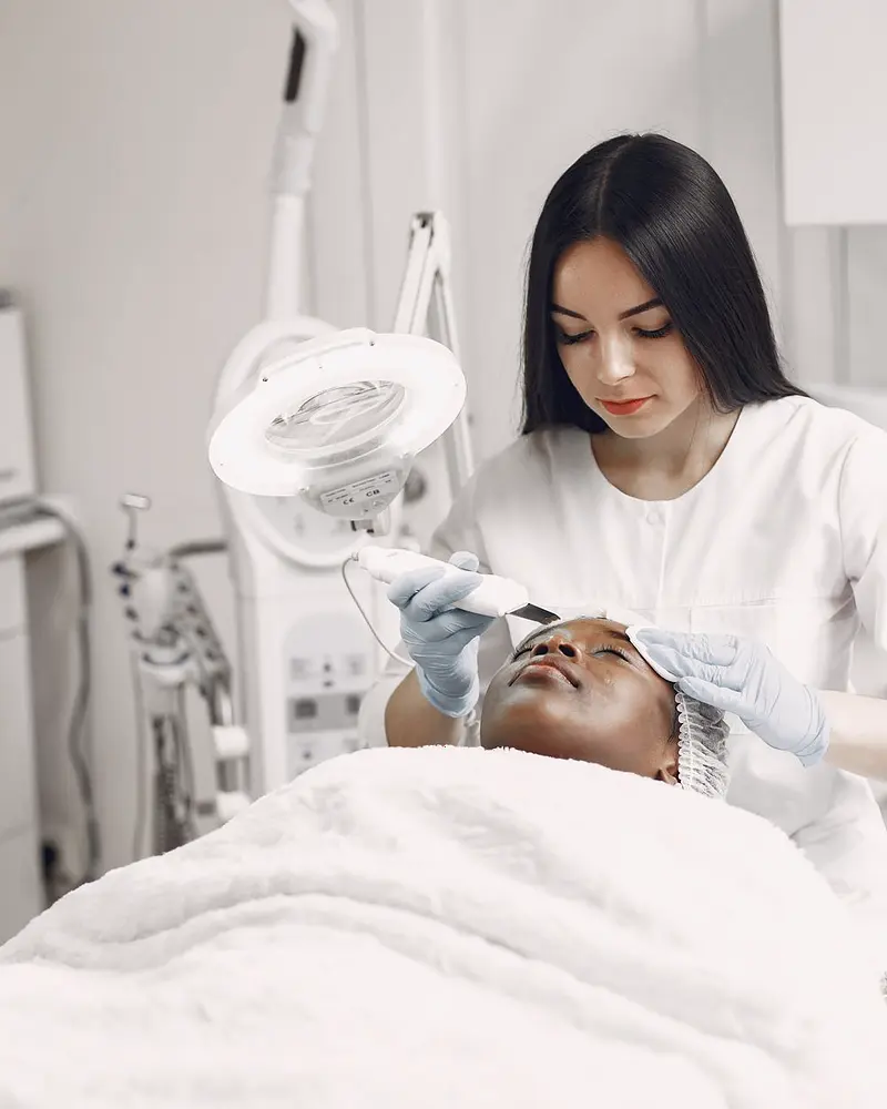 Esteticista realizando tratamento facial em cliente no studio